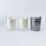 Three glass candle holders with decorative patterns on a white background