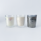 Three glass candle holders with decorative patterns on a white background