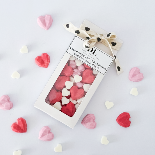 Box of heart-shaped wax melts with a decorative bow on a light background Darklight Beauty