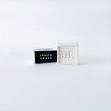 soap abeled 'Lemon Grass' next to a white box with 'DL' branding on a light gray background