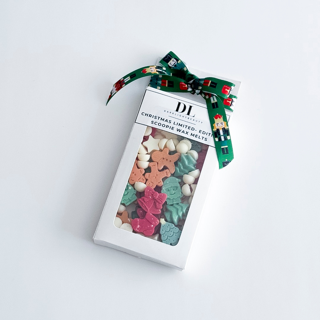 Box of Christmas-themed wax melts with a decorative bow on a white background