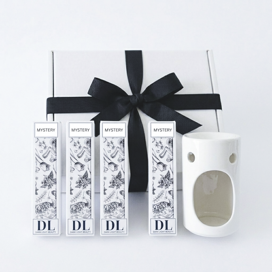 Set of mystery wax melts with Darklight Beauty branding and a white ceramic diffuser on a white background